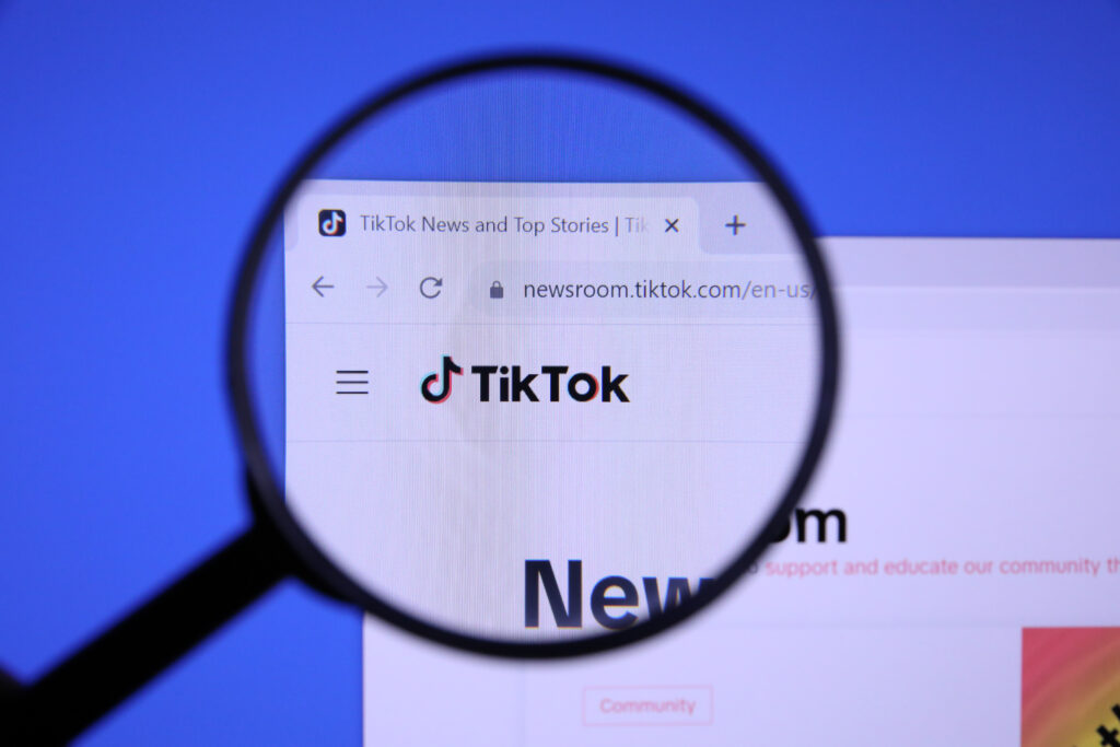 Homepage of TIKTOK Website magnified on logo with magnifying glass 53147161264